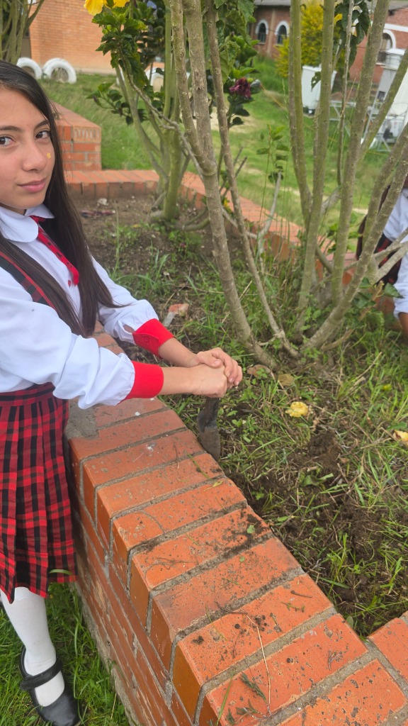 Estudiante realizando labores de jardinería y mantenimiento de zonas verdes